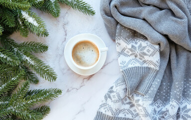 Obraz na płótnie Canvas coffee cup, knitted sweater and fir tree branches on marble background. Christmas and new year holidays concept. festive winter season. flat lay. copy space. template for design