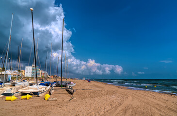 Xeraco Spain boats on beach with sea and waves between Gandia and Cullera holiday destination