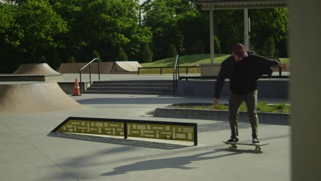 Male skateboarder doing a feeble grind on a rail at a skatepark