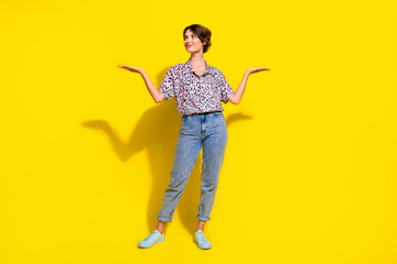 Full body photo of charming creative lady look arms hold empty space vs scales isolated on yellow color background