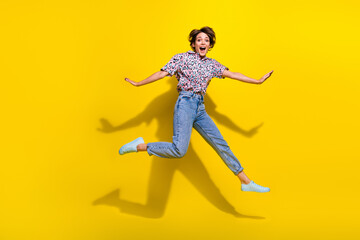 Full size photo of carefree gorgeous girl jumping rejoice have good mood isolated on yellow color background