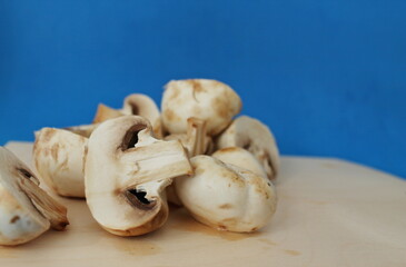 chopped champignons, mushrooms isolated, cutting board, cooking, ingredients, healthy food, blue background
