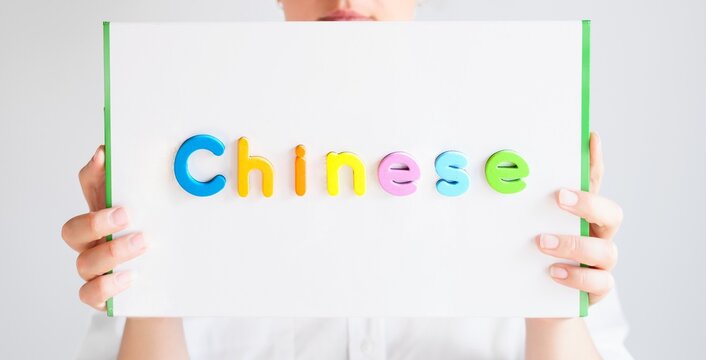 Learning Spanish educational courses. Native tutor, woman teacher in glasses with magnetic sign in hands. Study foreign language in online school. Speaking,reading,writing,linguistic knowledge skills