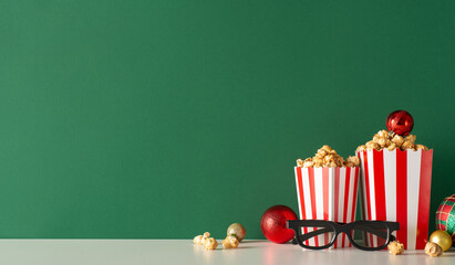 Red-carpet movie premiere with delicious snack concept. Side view shot of tabletop adorned with 3D glasses, mouthwatering popcorn in packaging with baubles against green wall, ready for movie advert