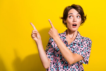 Photo of impressed crazy girl open mouth look indicate fingers empty space isolated on yellow color...
