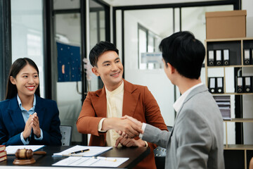 Judge and client shaking hands and lawyers discussing contract papers after adviced in background at courtroom, lawyer service concept..