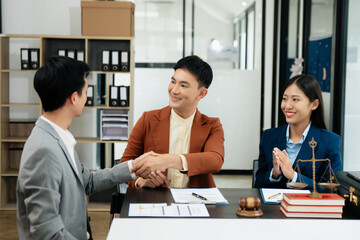 Judge and client shaking hands and lawyers discussing contract papers after adviced in background at courtroom, lawyer service concept..