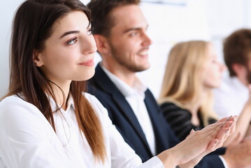 Beautiful smiling woman portrait with group of people listen carefully during seminar. Study event...