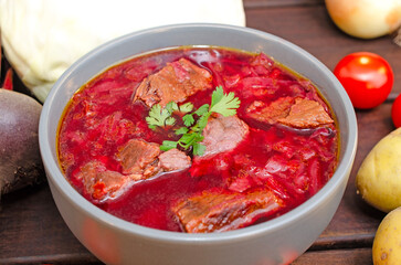 Borscht soup with vegetables and meat on a wooden table