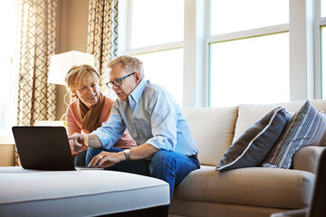 Laptop, talking or mature couple in home typing for savings, property investment or online shopping together. Ecommerce, website or senior people planning for investing or research on pc on sofa