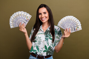 Photo of cheerful positive lovely lady wear trendy clothes hold money win lottery wealth luxury life isolated on beige color background