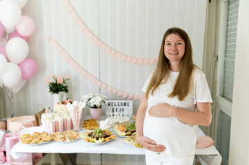 pregnant woman at baby shower. buffet with various appetizers and sweet dessert. expecting a child. holiday in the family