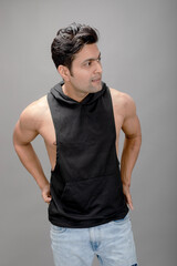 Indian young male model in casual wear wearing black tshirt and blue torn denim jeans. Male model. Fashion Portrait.