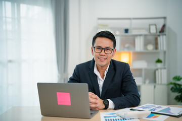 Smart Asian businessman with suit smiling wearing glasses working with computer laptop. concept...