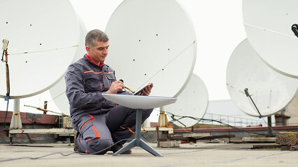 An engineer installs satellite internet antennas. Work process of modernization of...