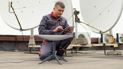 An engineer installs satellite internet antennas. Work process of modernization of telecommunication equipment. Concept of modern technologies and successful business.