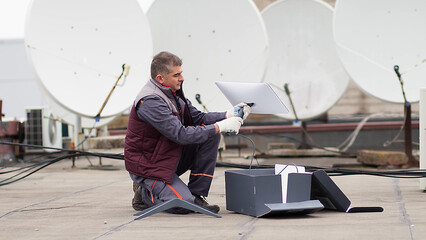 An engineer installs satellite internet antennas. Work process of modernization of...
