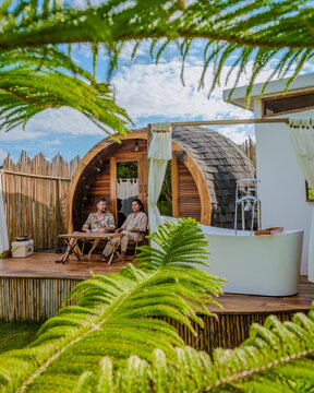 a couple of men and women camping in the mountains of Northern Thailand during vacation. Outdoor bathroom, and bathtub during sunset at the mountains at a igloo hut