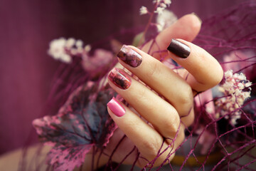 Short manicure with floral abstract nail design with Geyhera leaves. - obrazy, fototapety, plakaty