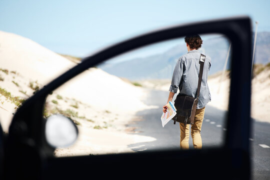 Lost, man and map for travel in car, journey and driver on a road trip and adventure. Confused, direction and person walking to check location with transport to explore countryside or search guide