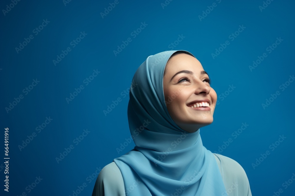 Sticker portrait of a beautiful young muslim woman smiling on blue background