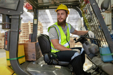 Warehouse worker wears safety helmet driving forklift truck in pallet factory. Skilled male logistic engineer working in shipping storage manufacturing lifting, moving and unloading cargo for delivery