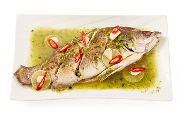 Steamed sea bass with lemon (Steamed snapper with lemon) in a white plate isolated on white background. It is a popular menu in Thailand. High in protein, low in calories. The taste is sour and spicy.