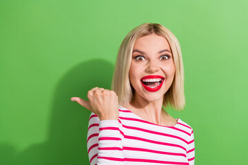 Fototapeta premium Photo of impressed woman with bob hairdo dressed striped shirt look directing at empty space discount isolated on green color background