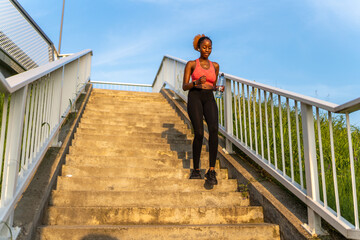 The African American girl's determination fuels her as she conquers the staircase, transforming it into a dynamic and energizing component of her fitness regimen.