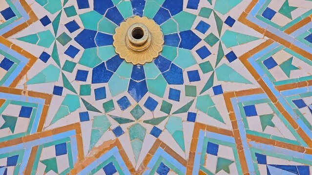 pan shot on Moroccan Colorful zellige tiles pattern of a fountain in Hassan II Mosque Casablanca Morocco. Mosaic pattern, traditional Islamic geometric design. Moroccan craft, handmade.