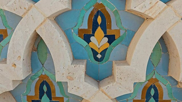 pan shot on Moroccan Colorful zellige tiles pattern in Hassan II Mosque in Casablanca . Mosaic pattern, traditional Islamic geometric design. Moroccan craft, handmade.