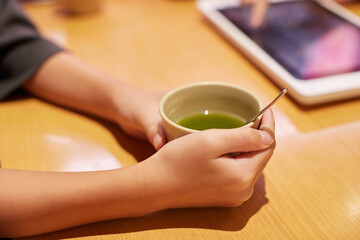 喫茶店でお茶を飲みながら注文する女性の手のアップ写真 - obrazy, fototapety, plakaty