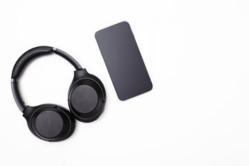 Noise-canceling headphones and a smartphone on a white background. Isolated