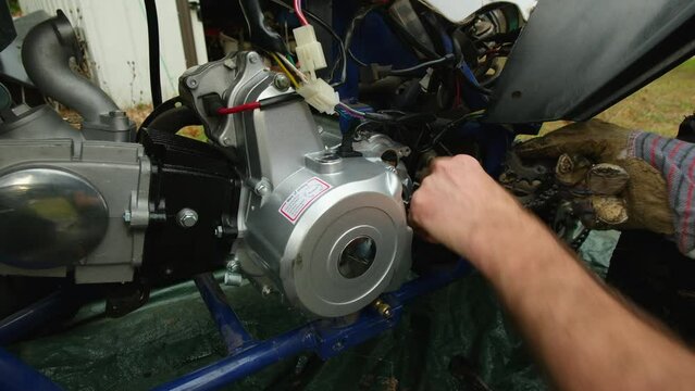 Installing chain gear and other parts into newly replaced gas motor in four wheeler.