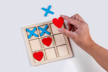 Love always wins. Tic-tac-toe board, playing with hearts.