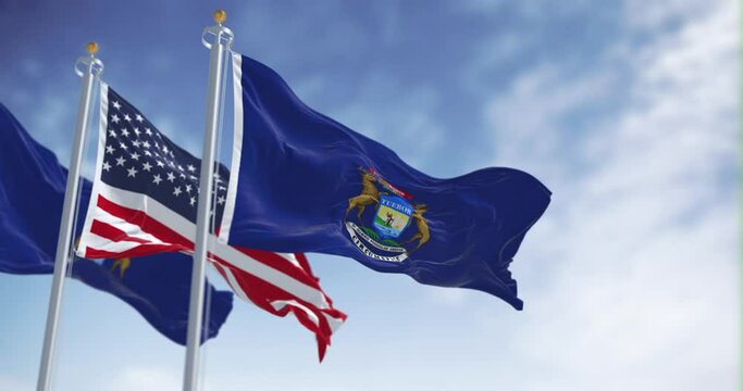 Two flags of the state of Michigan waving in the wind with the american flag