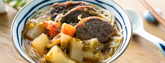 Beef noodle soup. Taiwanese famous food in a bowl on wooden table.