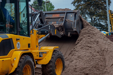 Radlader auf Baustelle fährt auf Sandberg