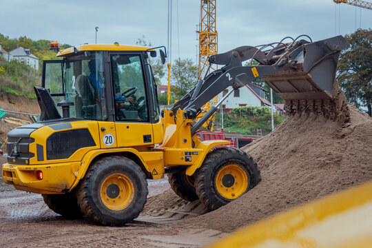 Radlader auf Baustelle f&auml;hrt auf Sandberg