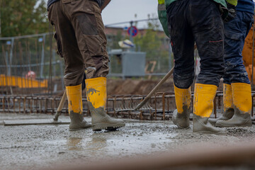 Bauarbeiter verteilen Beton auf einer Baustelle