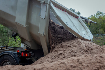 LKW endlädt Sand auf Baustelle