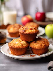 Fresh baked cupcakes with apples and crumbles on top, white plate and blurred background