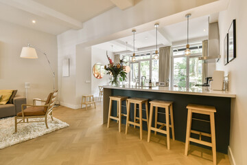 a living room with wood flooring and white walls in the center of the room is a black kitchen island