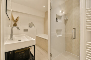 a bathroom with a sink, mirror and towel rack in the shower stall door is open on the right side
