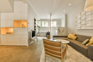 a living room with wood flooring and white cabinetd walls in the center of the room there is a couch, coffee table