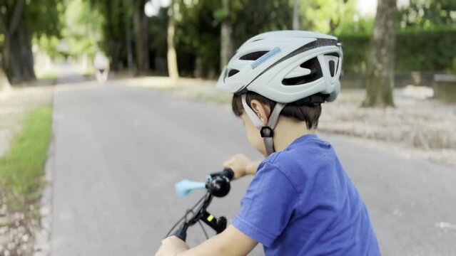 Young Boy Cycling in the Park During the Day with a Helmet, Still Gaining Confidence - Loses Balance and Focus When Overtaken by a Group of Cyclists