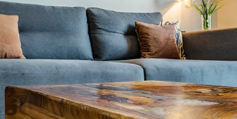 Fotobehang live edge wooden accent coffee table near sofa close up interior design of modern living roo  © Enzo