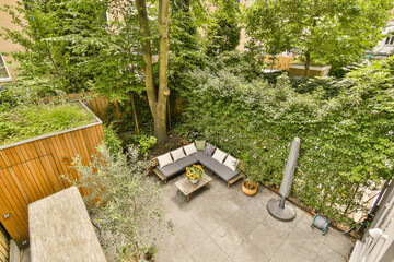 an outdoor living area with furniture and trees in the back yard, looking down onto the backyard patio from above