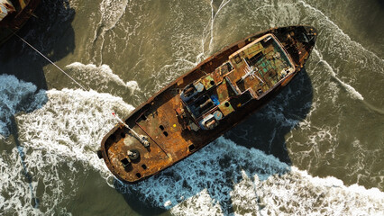 Top-down view of sunken ship covered with rust. Ancient ship that are moored off the coast of the...