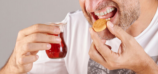 Man is eating fruits, close up mouth in the kitchen style.
